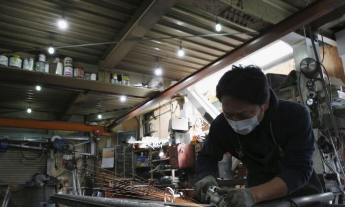 An engineer makes an arm rail for residential buildings inside a metal processing factory at an industrial zone in downtown Tokyo, Japan, on March 22, 2016. (Yuya Shino/Reuters)
