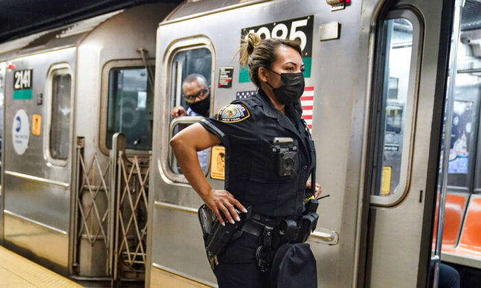 A New York Police Department officer and a subway conductor look down the subway platform at the Grand Central subway station in New York, on May 18, 2021. (Frank Franklin II/AP Photo)