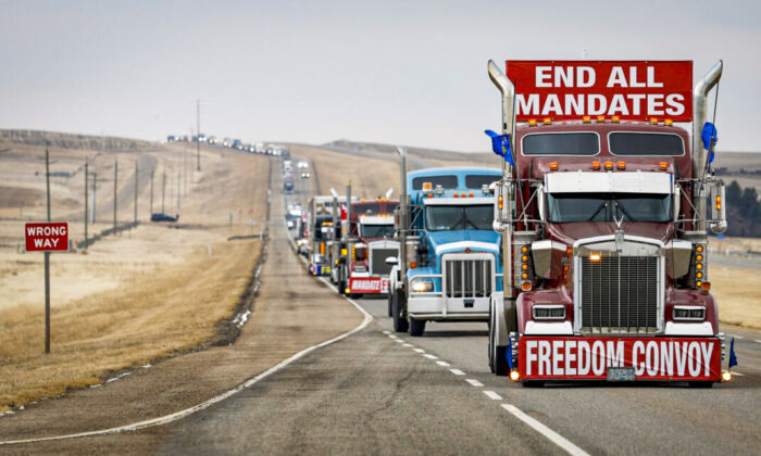 Protesters leave in a truck convoy at the U.S. border crossing after demonstrating against COVID-19 mandates for over two weeks, in Coutts, Alberta, on Feb. 15, 2022. (Jeff McIntosh/The Canadian Press)
