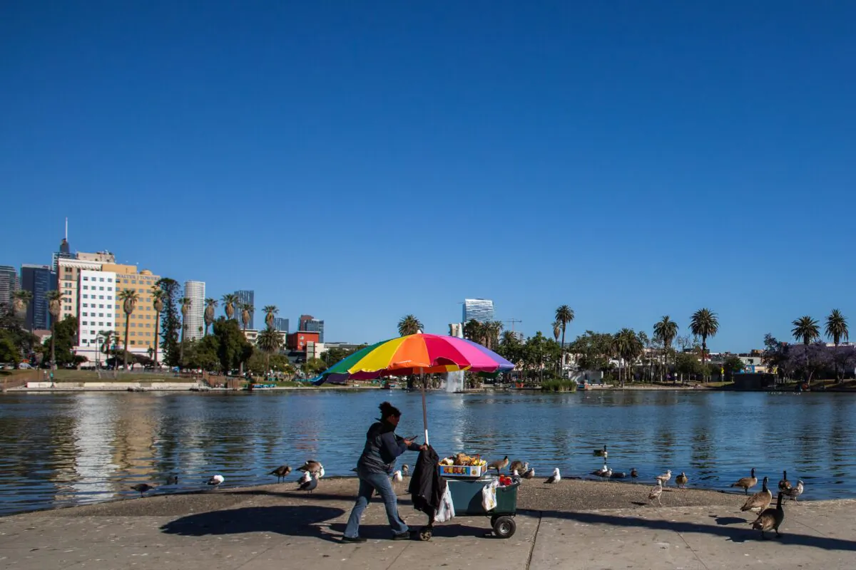 A street vendor pushes her cart in MacArthur Park, Los Angeles on May 21, 2020. (Apu Gomes/AFP via Getty Images)