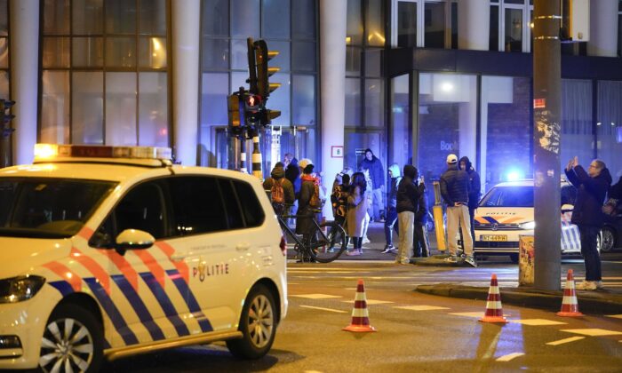 Police vehicles cordon off a wide area in Amsterdam, where an armed person is holed up in the Apple Store with at least one hostage in an hours-long standoff with scores of police massed outside, in Amsterdam, on Feb. 22, 2022. (Peter Dejong/AP Photo)