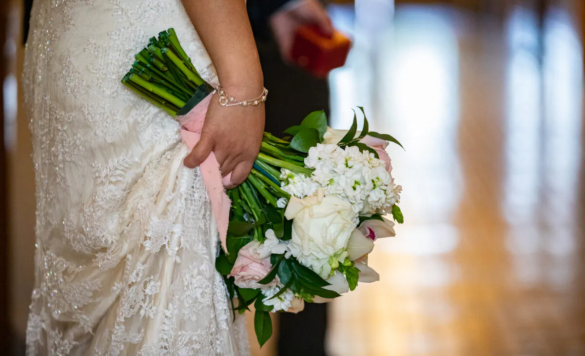 A bride holds a wedding bouquet at Old Orange County Courthouse in Santa Ana, Calif., on Feb. 22, 2022. (John Fredricks/The Epoch Times)