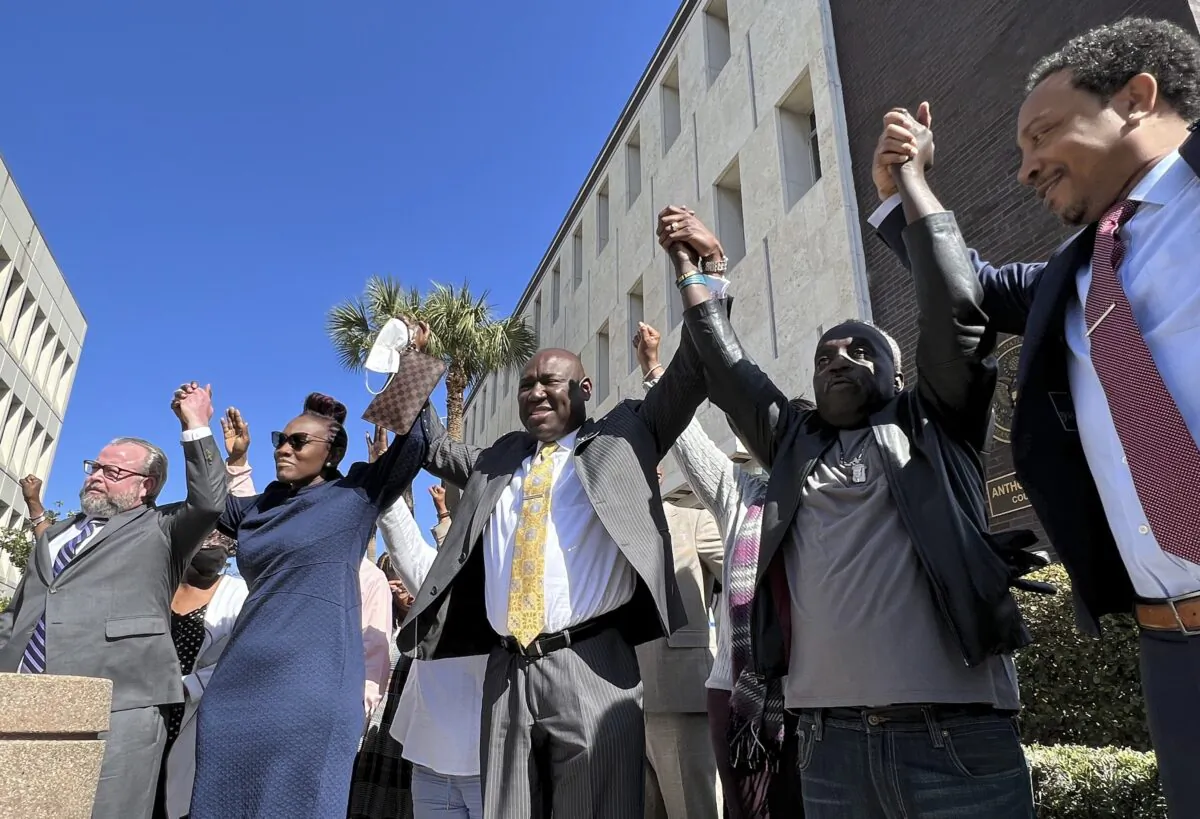 The family and attorneys of the Ahmaud Aubery raise their arms in victory after all three men were found guilty of hates crimes at the federal courthouse in Brunswick, Ga., on Feb. 22, 2022. (Lewis M. Levine/AP Photo)