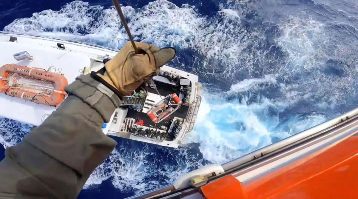 A Coast Guard Air Station Miami MH-65 Dolphin helicopter crew rescues a man after he was bitten by a shark while fishing aboard a vessel near Bimini, Bahamas, on Feb. 21, 2022. (U.S. Coast Guard via AP)