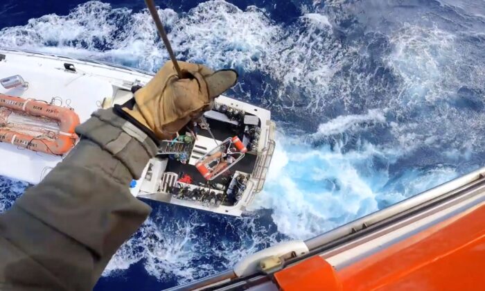A Coast Guard Air Station Miami MH-65 Dolphin helicopter crew rescues a man after he was bitten by a shark while fishing aboard a vessel near Bimini, Bahamas, on Feb. 21, 2022. (U.S. Coast Guard via AP)