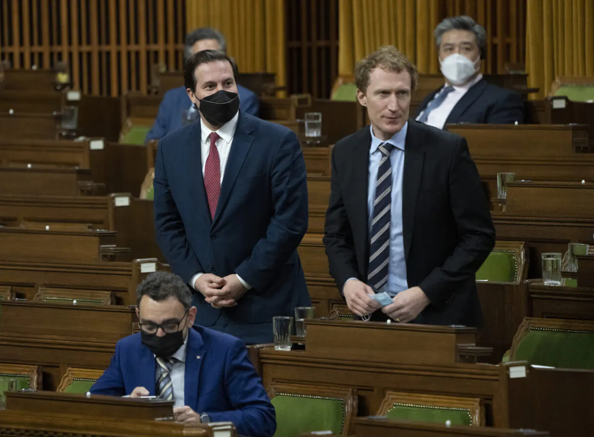Public Safety Minister Marco Mendicino, right, and Crown-Indigenous Relations Minister Marc Miller rise to vote on the implementation of the Emergencies Act, in Ottawa, on Feb. 21, 2022. (The Canadian Press/Adrian Wyld)