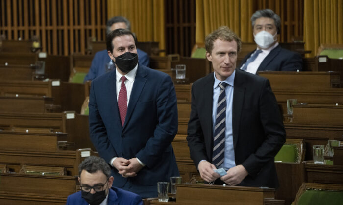 Public Safety Minister Marco Mendicino, right, and Crown-Indigenous Relations Minister Marc Miller rise to vote on the implementation of the Emergencies Act, in Ottawa, on Feb. 21, 2022. (The Canadian Press/Adrian Wyld)