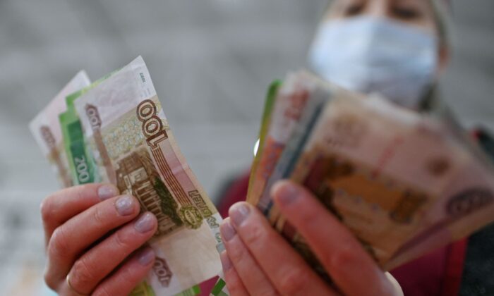 A vendor counts Russian rouble banknotes at a market in Omsk, Russia, on Feb. 18, 2022. (Alexey Malgavko/Reuters)