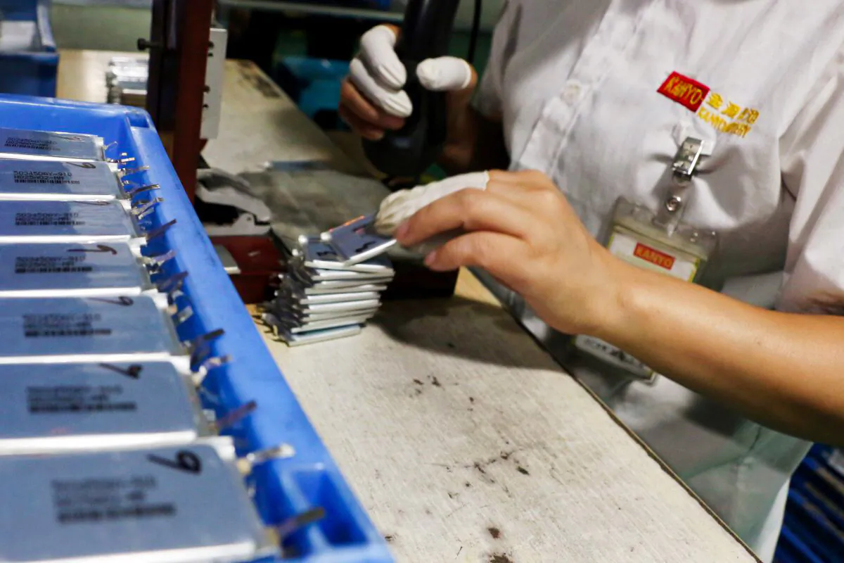 An employee works at a production line of lithium-ion batteries inside a factory in Dongguan, Guangdong Province, China, on Oct. 16, 2018. (Joyce Zhou/Reuters)