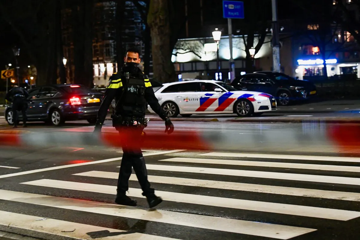 A police officer walks near an Apple store in central Amsterdam during a hostage incident in the store, in Amsterdam, Netherlands, on Feb. 22, 2022. (Piroschka van de Wouw/Reuters)
