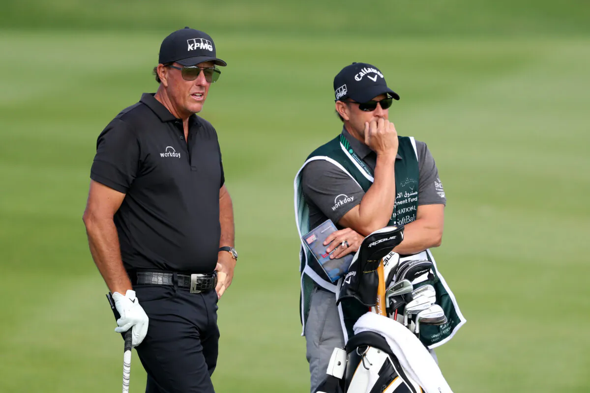 Phil Mickelson of the United States looks down the 17th hole with caddie during day two of the PIF Saudi International at Royal Greens Golf & Country Club, in Al Murooj, Saudi Arabia, on Feb. 4, 2022. (Oisin Keniry/Getty Images)
