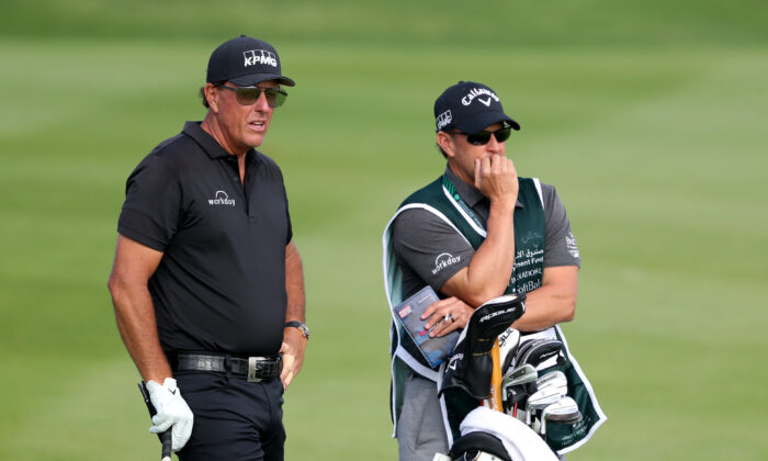 Phil Mickelson of the United States looks down the 17th hole with caddie during day two of the PIF Saudi International at Royal Greens Golf & Country Club, in Al Murooj, Saudi Arabia, on Feb. 4, 2022. (Oisin Keniry/Getty Images)