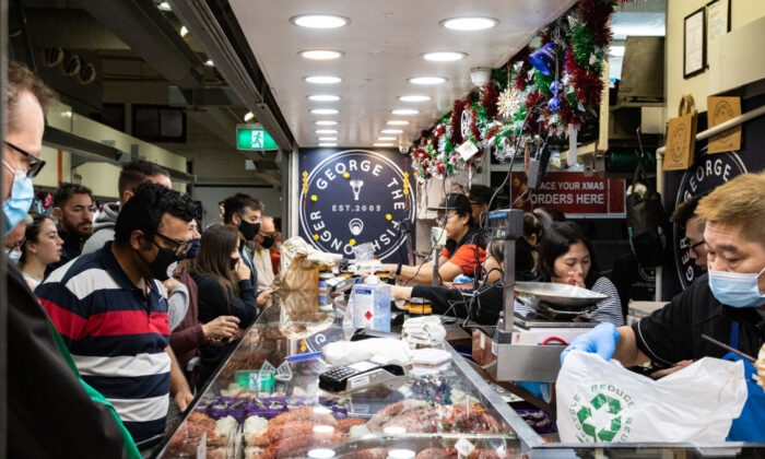 People wear a face mask as they shop at George the Fishgonger shop at the Queen Victoria Market in Melbourne, Australia, on Dec. 24, 2021. (Diego Fedele/Getty Images)