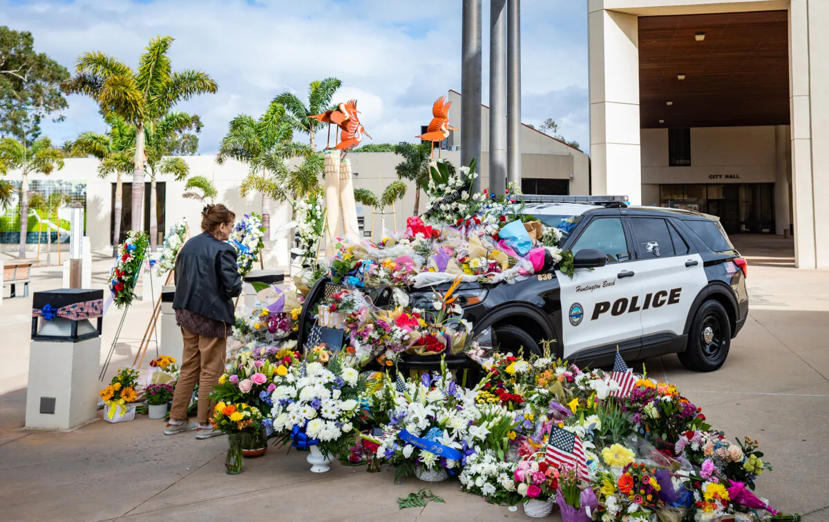 A growing memorial of flowers for the passing of Huntington Beach Police Officer Nicholas Vella is displayed near the Huntington Beach Police station in Huntington Beach, Calif., on Feb. 22, 2022. (John Fredricks/The Epoch Times)