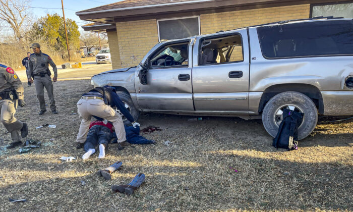 Law enforcement and emergency personnel aid the driver and passenger of a truck that rolled and hit a house during a high-speed chase in Brackettville, Texas, on Feb. 18, 2022. (Courtesy of Kinney County Sheriff’s Office)