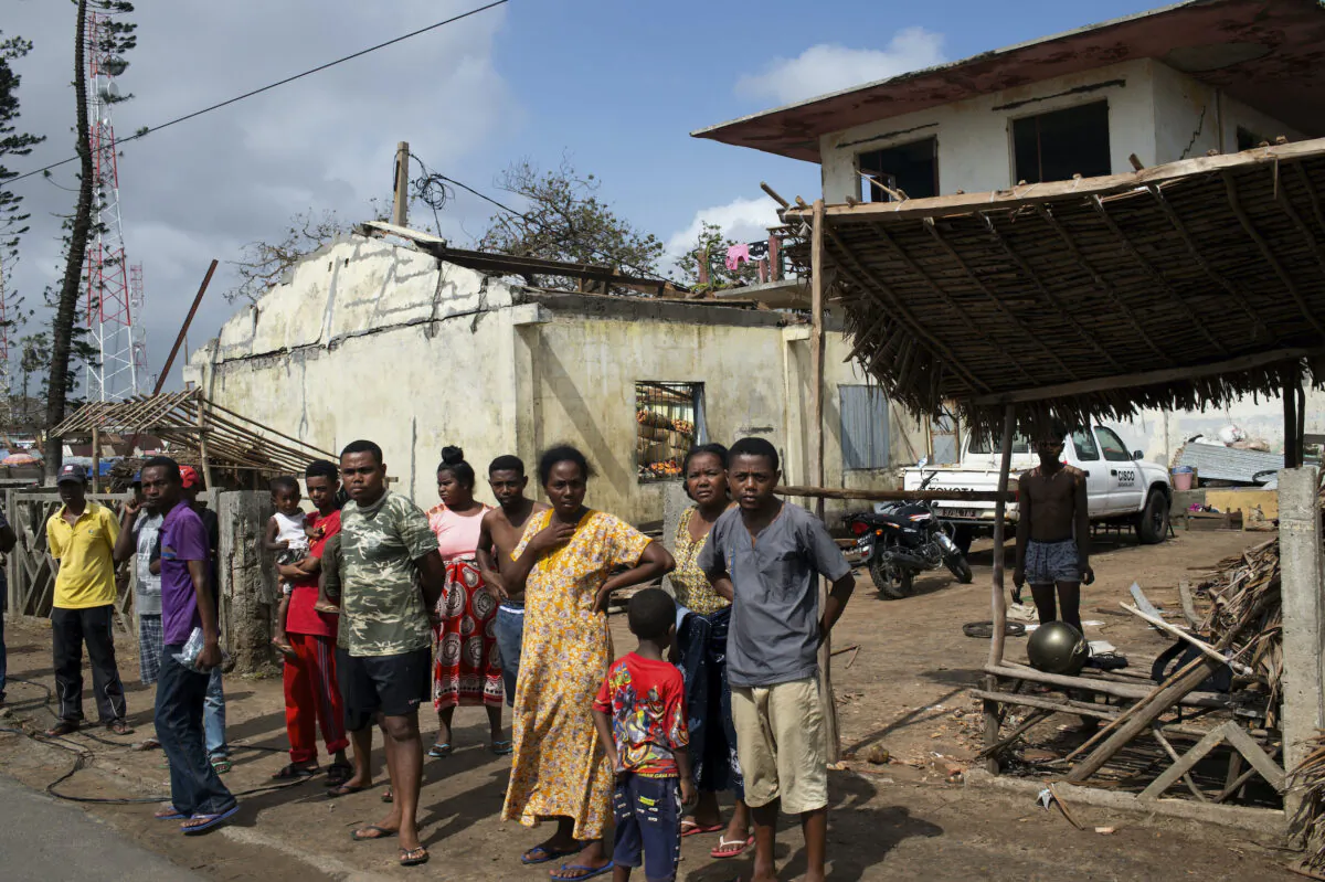 People outside ruined homes in Mananjary, Madagascar, on Feb. 10, 2022. (Viviane Rakotoarivony/AP Photo)