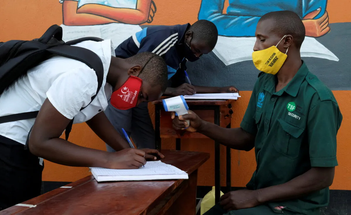 Students register and have their temperatures taken at Bukere Secondary School in Kyaka II Refugee Settlement, Kyegegwa District, Uganda, on Jan. 11, 2022. (Esther Ruth Mbabazi/Reuters)