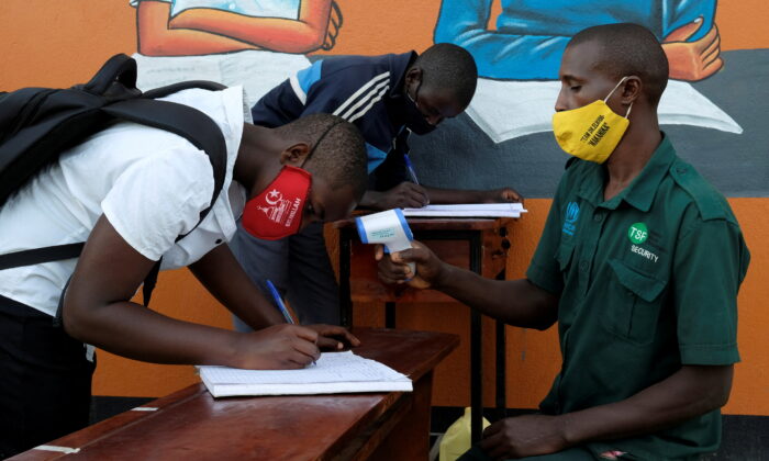 Students register and have their temperatures taken at Bukere Secondary School in Kyaka II Refugee Settlement, Kyegegwa District, Uganda, on Jan. 11, 2022. (Esther Ruth Mbabazi/Reuters)