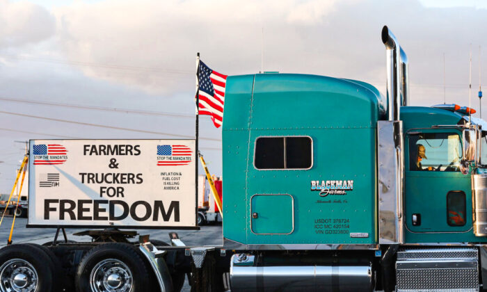 A trucker sits in his cab as truck drivers and supporters gather one day before "The People’s Convoy" departs for Washington to protest COVID-19 mandates, in Adelanto, Calif., on Feb. 22, 2022. (Mario Tama/Getty Images)