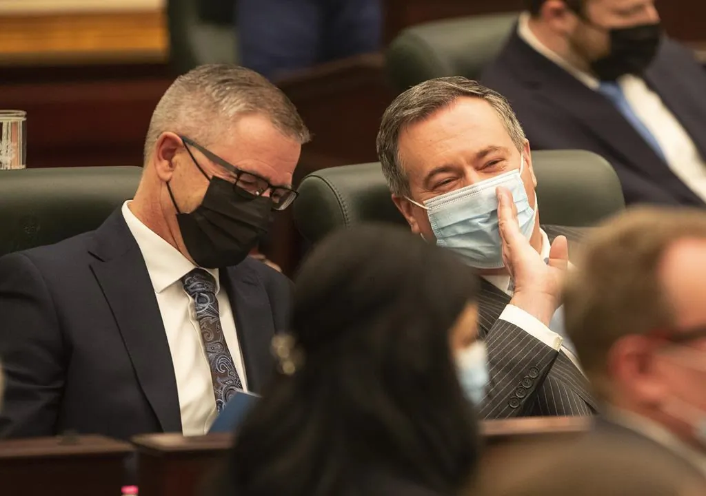 Alberta finance minister Travis Toews and Alberta Premier Jason Kenney Lieutenant Governor chat during the speech from the throne in Edmonton Alta, on Feb. 22, 2022. (The Canadian Press/Jason Franson)
