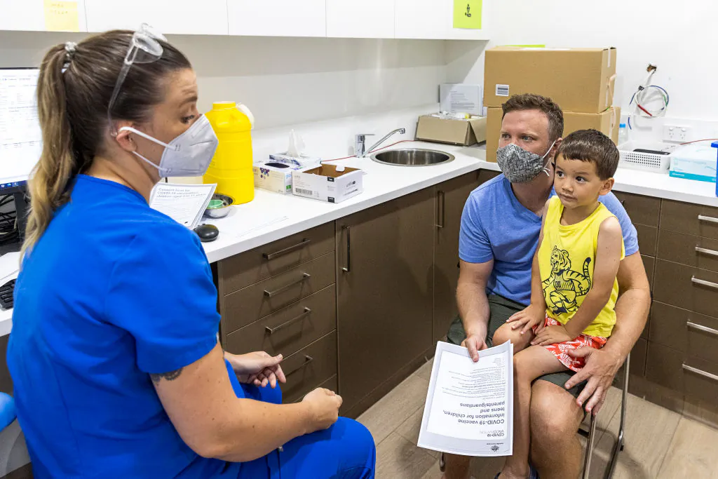 Registered nurse Emma Ahearn talks to Stephen Delaney ahead of son Lachlan Delany receiving his COVID-19 vaccine in Sydney, Australia, on Jan. 11, 2022. (Jenny Evans/Getty Images)