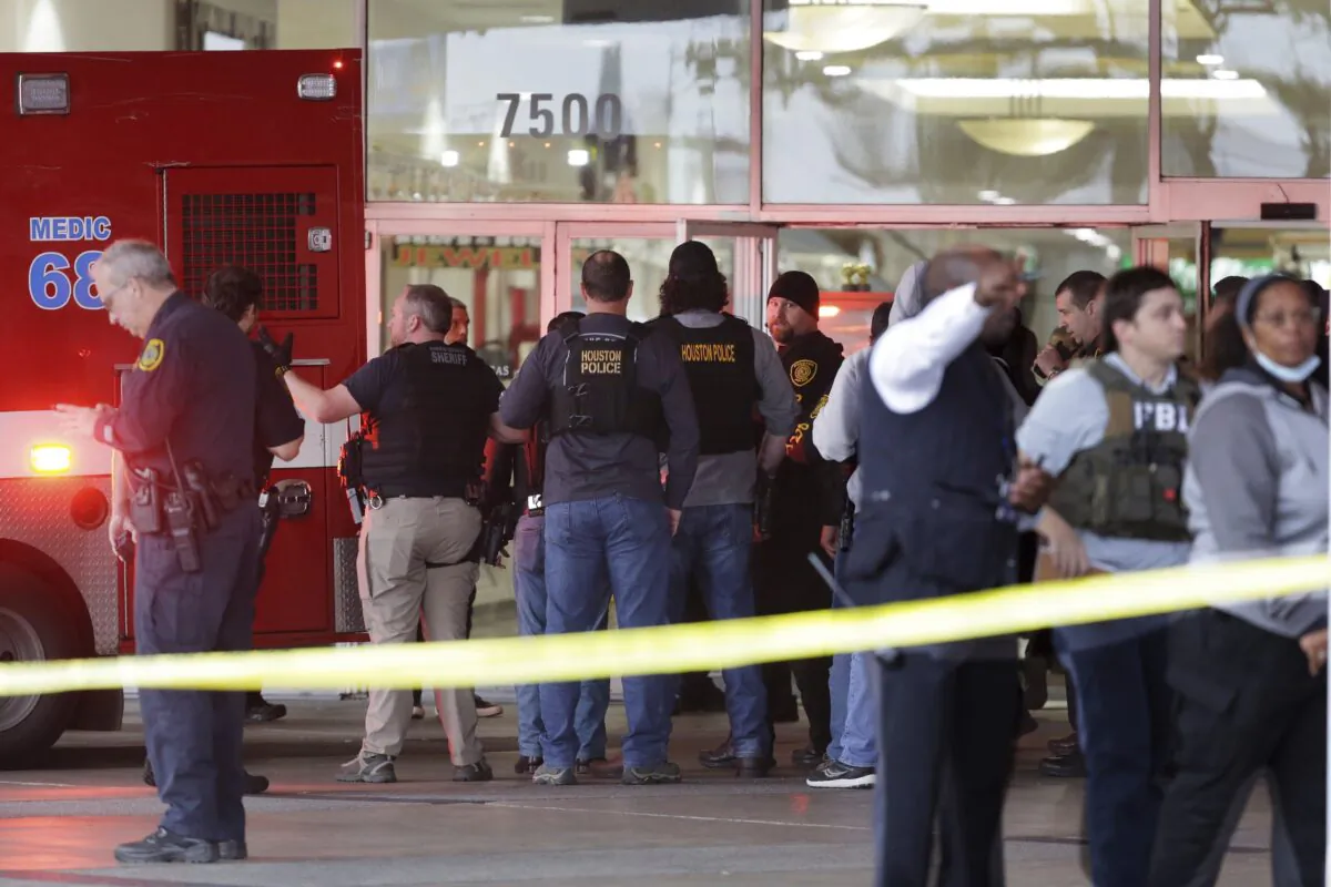 Police gather at the main south entrance of PlazAmericas Mall as an ambulance backs into the area to take a patient after a shooting in Houston on Feb. 23, 2022. (Michael Wyke/Houston Chronicle via AP)