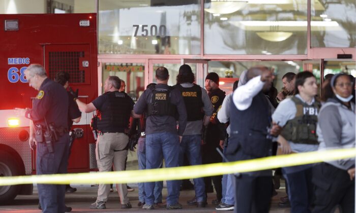 Police gather at the main south entrance of PlazAmericas Mall as an ambulance backs into the area to take a patient after a shooting in Houston on Feb. 23, 2022. (Michael Wyke/Houston Chronicle via AP)