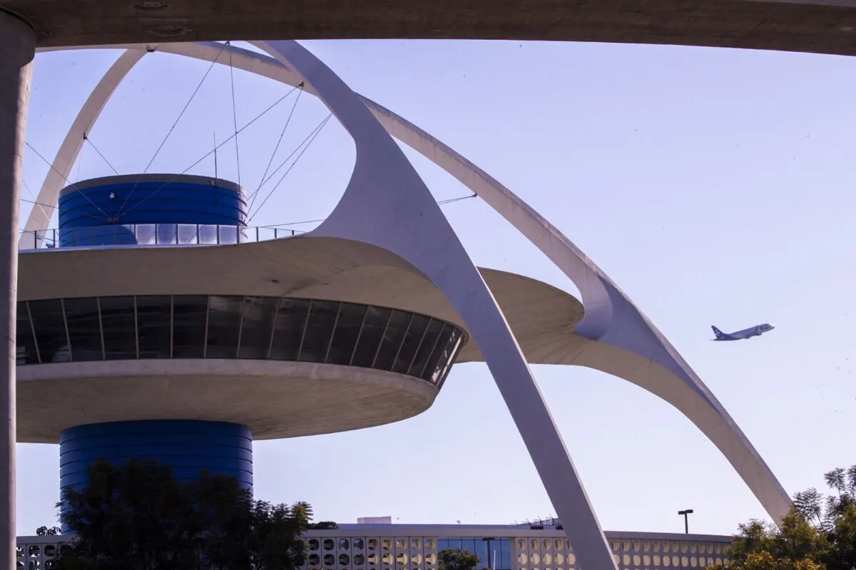 An airplane lifts off as viewed with the Theme Building in the foreground of Los Angeles International Airport, in Los Angeles, on Nov. 23, 2021. (Allen J. Schaben/Los Angeles Times/TNS)