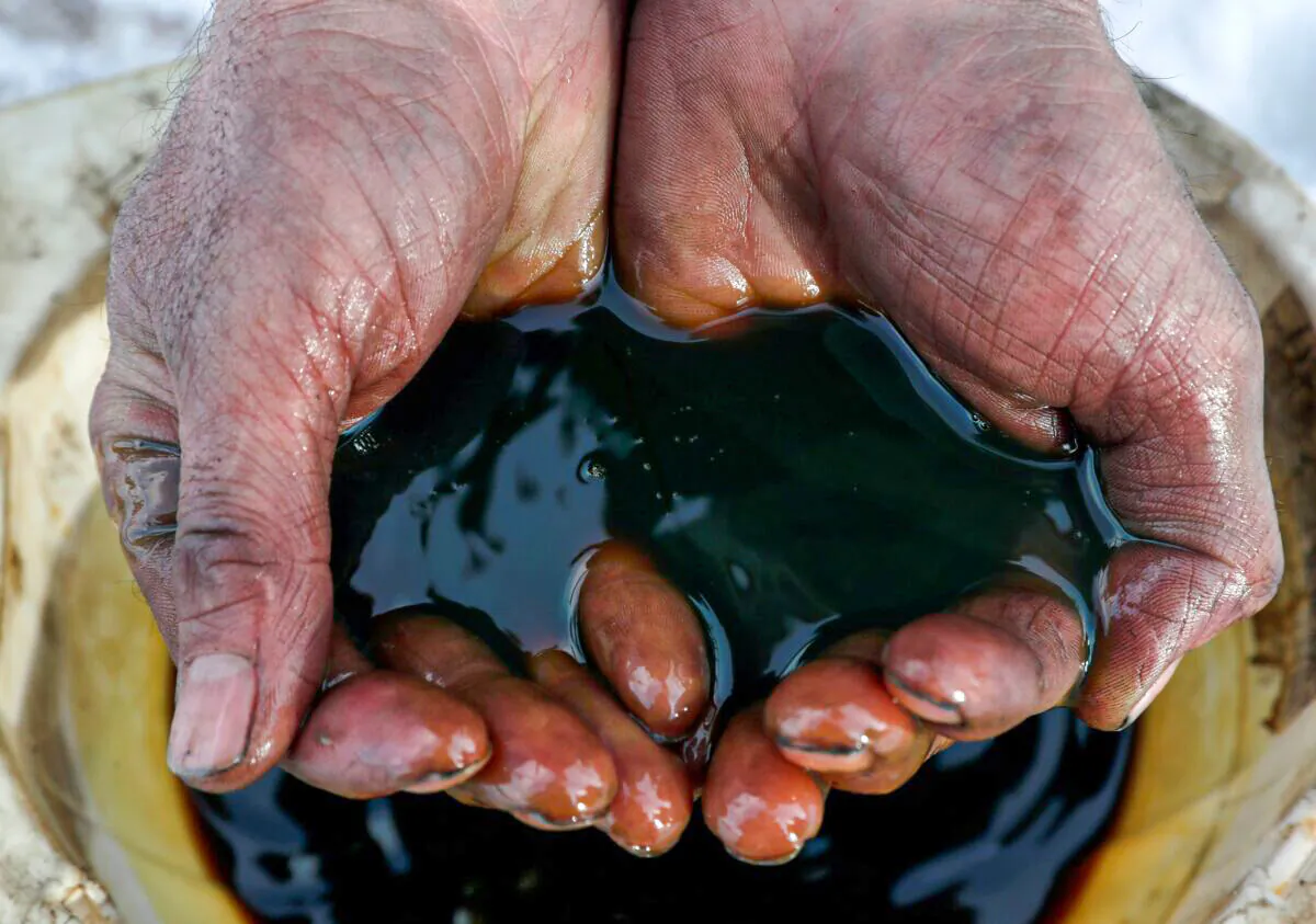 An employee holds a sample of crude oil at the Yarakta oilfield, owned by Irkutsk Oil Co., in the Irkutsk region, Russia, on March 11, 2019. (Vasily Fedosenko/Reuters)