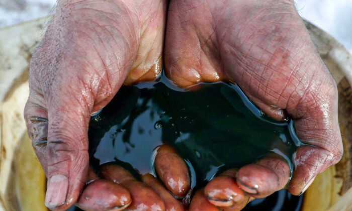 An employee holds a sample of crude oil at the Yarakta oilfield, owned by Irkutsk Oil Co., in the Irkutsk region of Russia on March 11, 2019. (Vasily Fedosenko/Reuters)