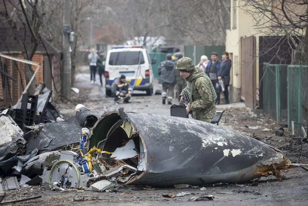 A Ukrainian Army soldier inspects fragments of a downed aircraft in Kyiv, Ukraine, Feb. 25, 2022.(The Canadian Press/AP/Vadim Zamirovsky)