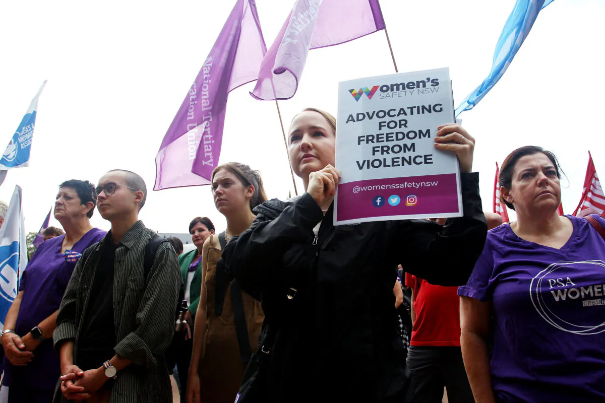 A woman holds a protest sign calling for action against domestic violence in Hyde Park during the Sydney International Women's Day march in Sydney, Australia, on March 7, 2020. (Lisa Maree Williams/Getty Images)