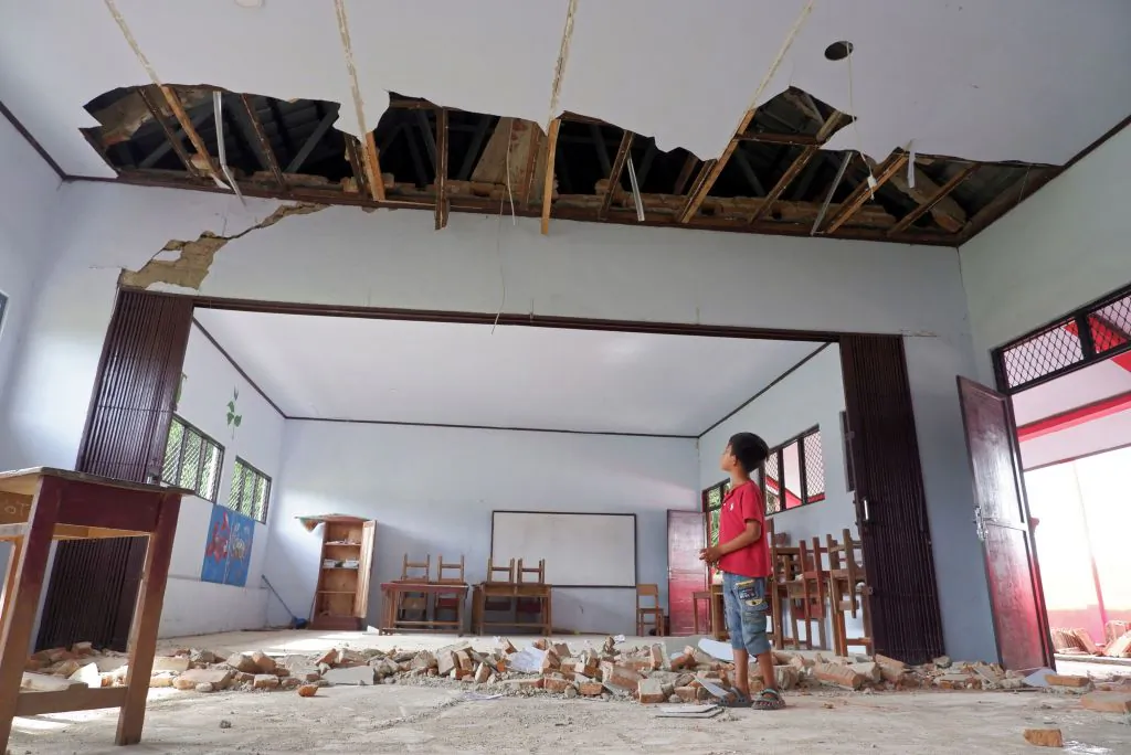 A boy looks at his damaged classroom a day after a 6.2-magnitude earthquake hit the area at Kertamukti village in Pandeglang, Indonesia, on Jan. 15, 2022. (Dziki Oktomauliyadi/AFP via Getty Images)