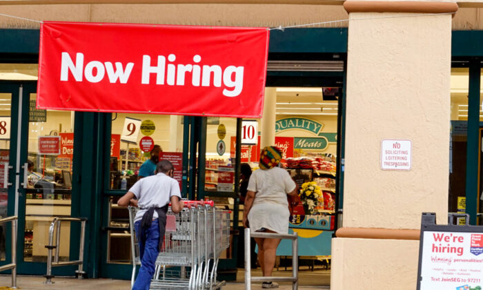 A Now Hiring sign hangs near the entrance to a Winn-Dixie Supermarket in Hallandale, Fla., on Sept. 21, 2021. (Joe Raedle/Getty Images)