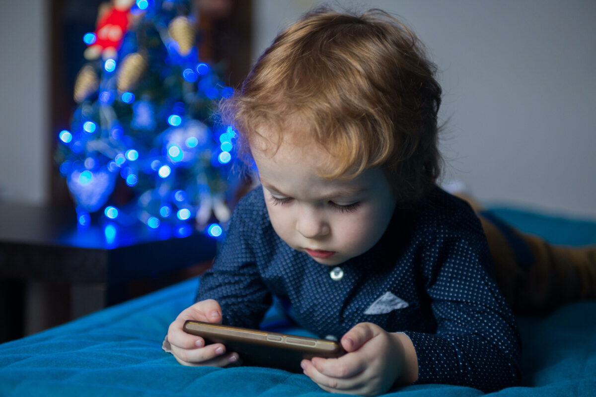 A,Little,Boy,Holds,A,Smartphone,In,His,Hands,,Plays