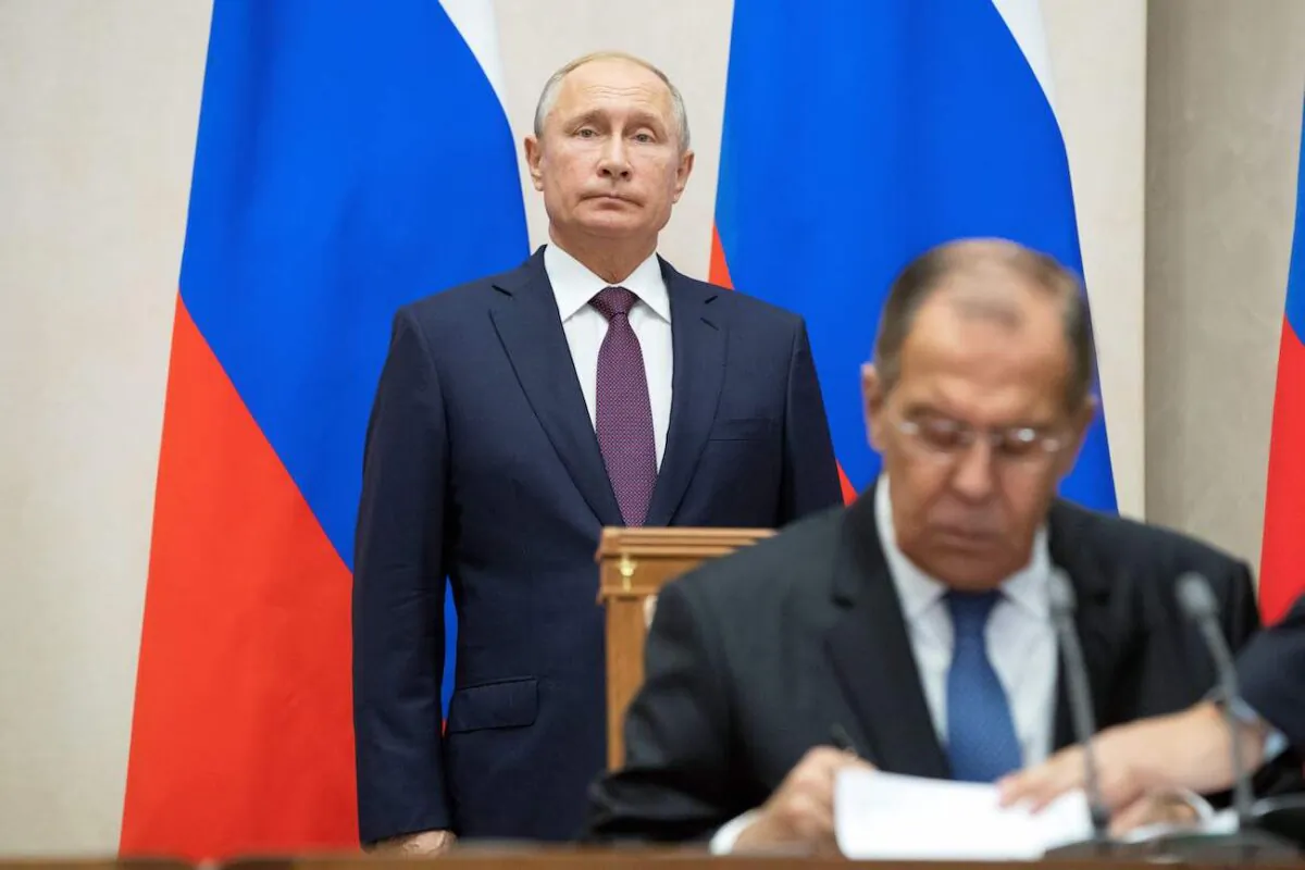 Russian Foreign Minister Sergei Lavrov (R) signs documents as Russian President Vladimir Putin attends a signing ceremony in Sochi, Russia, on Oct. 17, 2018. (Pavel Golovkin/Pool/AFP via Getty Images)