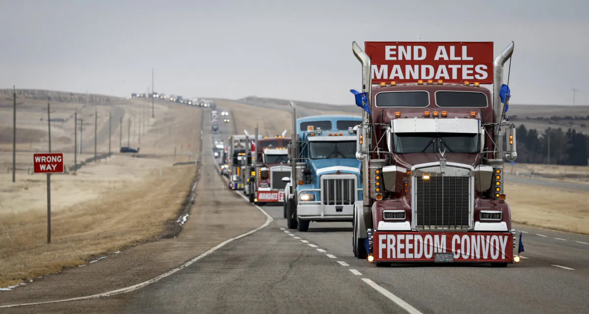 Protesters in a truck convoy leave the Canada-U.S. border crossing after demonstrating against COVID-19 mandates for over two weeks, in Coutts, Alberta, on Feb. 15, 2022. (Jeff McIntosh/The Canadian Press)