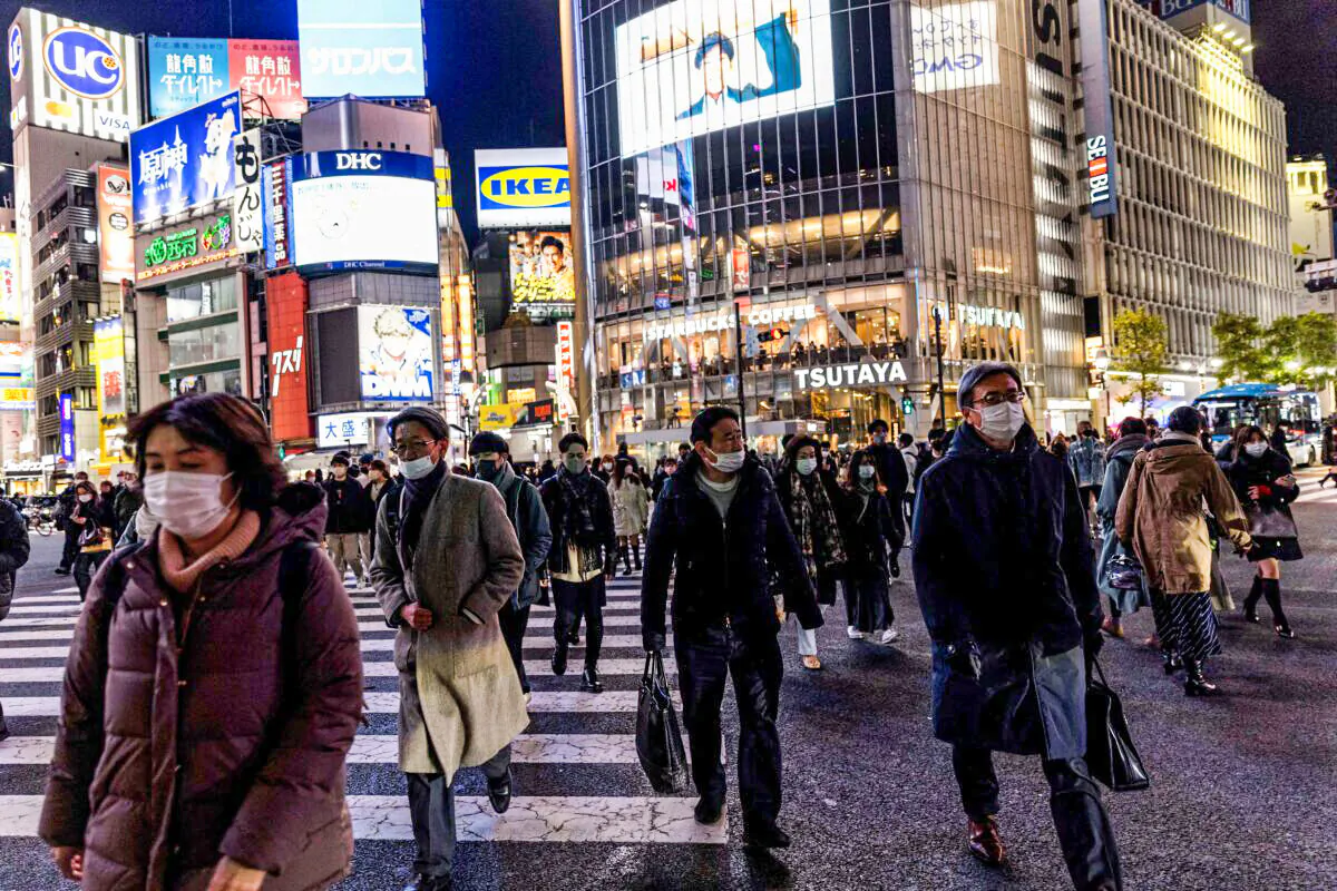 People wearing protective masks walk at Shibuya district in Tokyo on Jan. 19, 2022. (Behrouz Mehri/AFP via Getty Images)