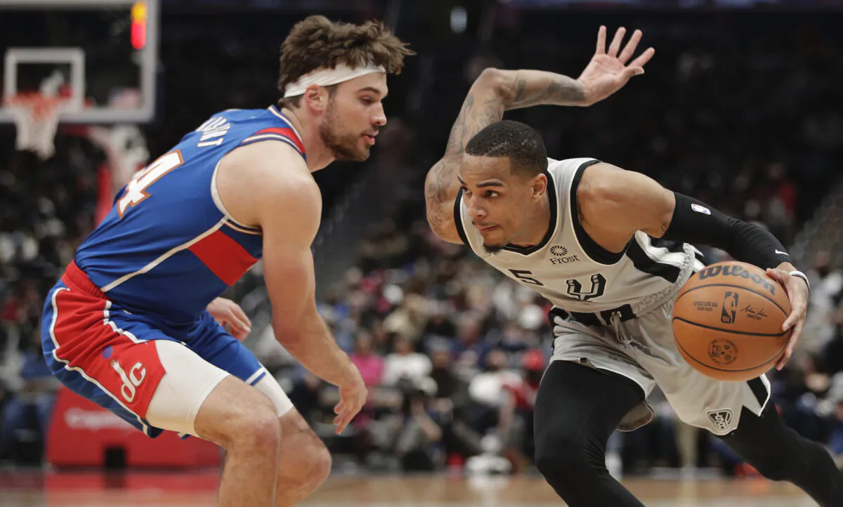San Antonio Spurs' Dejounte Murray (R) moves the ball as Washington Wizards’ Corey Kispert (L) defends during the second half of an NBA basketball game in Washington, on Feb. 25, 2022. (Luis M. Alvarez/AP Photo)