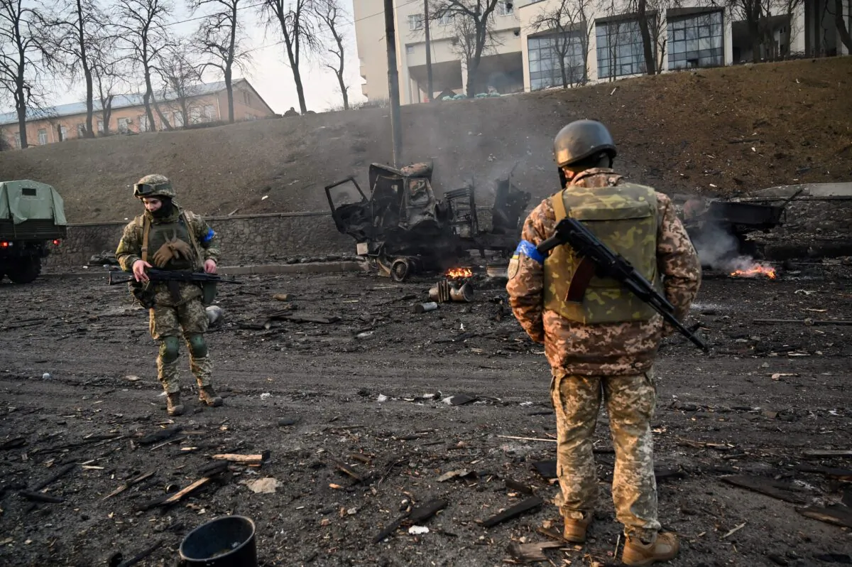 Ukrainian service members look for unexploded shells after fighting with Russian forces in Kyiv, Ukraine on Feb. 26, 2022. (Sergei Supinsky/AFP via Getty Images)