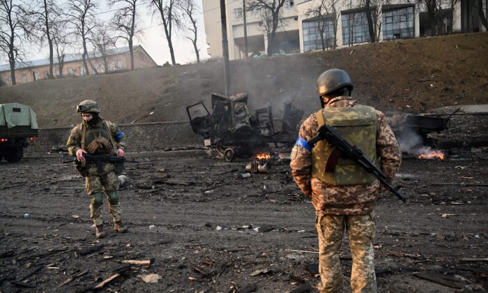 Ukrainian service members look for unexploded shells after fighting with Russian forces in Kyiv, Ukraine on Feb. 26, 2022. (Sergei Supinsky/AFP via Getty Images)