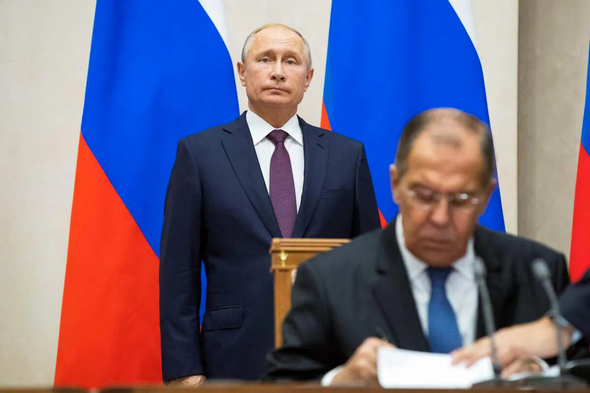 Russian Foreign Minister Sergei Lavrov (R) signs documents as Russian President Vladimir Putin attends a signing ceremony in Sochi, Russia, on Oct. 17, 2018. (Pavel Golovkin/Pool/AFP via Getty Images)