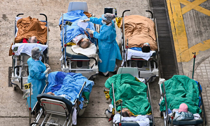 Patients lie on hospital beds at a temporary holding area outside Caritas Medical Centre in Hong Kong on Feb. 16, 2022. (Sung Pi-Lung/The Epoch Times)