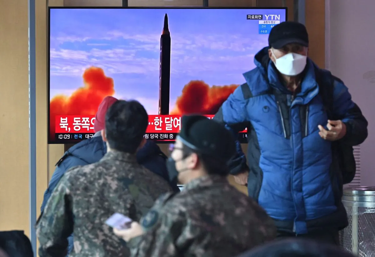 People watch a television screen showing a news broadcast with file footage of a North Korean missile test, at a railway station in Seoul, South Korea, on Feb. 27, 2022. (Jung Yeon-je/AFP via Getty Images)