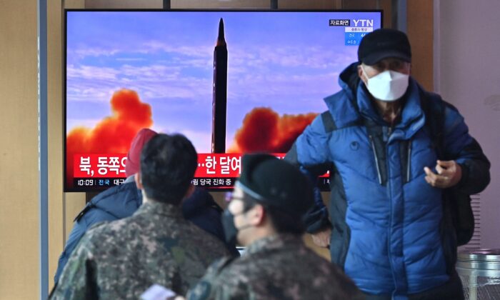 People watch a television screen showing a news broadcast with file footage of a North Korean missile test, at a railway station in Seoul, South Korea, on Feb. 27, 2022. (Jung Yeon-je/AFP via Getty Images)
