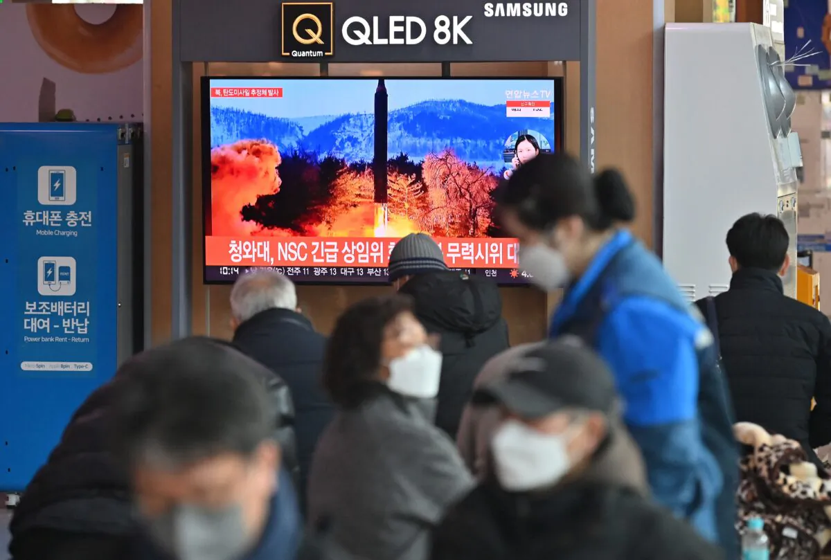 People watch a television screen showing a news broadcast with file footage of a North Korean missile test, at a railway station in Seoul, South Korea, on Feb. 27, 2022, after North Korea fired an "unidentified projectile" according to the South's military. (Jung Yeon-je/AFP via Getty Images)