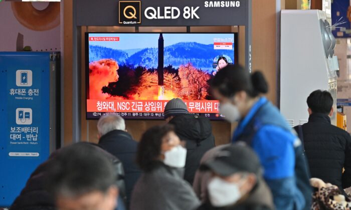People watch a television screen showing a news broadcast with file footage of a North Korean missile test, at a railway station in Seoul, South Korea, on Feb. 27, 2022, after North Korea fired an "unidentified projectile" according to the South's military. (Jung Yeon-je/AFP via Getty Images)