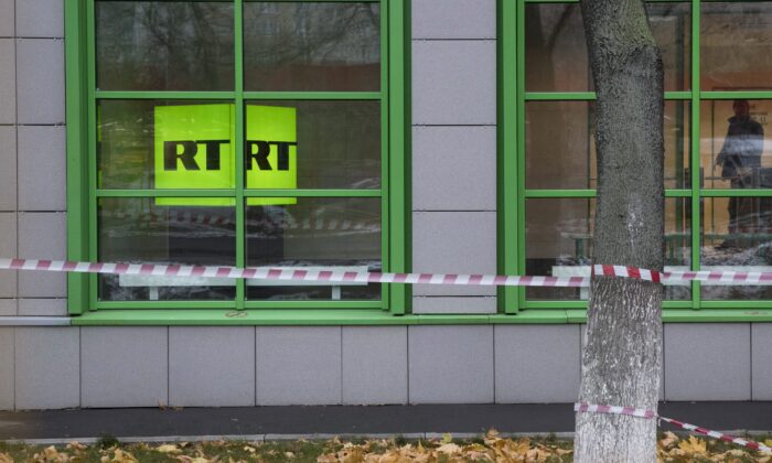 Russian state-owned television station RT logo is seen at the window of the company's office in Moscow, Russia, on Oct. 27, 2017. (AP Photo/Pavel Golovkin)