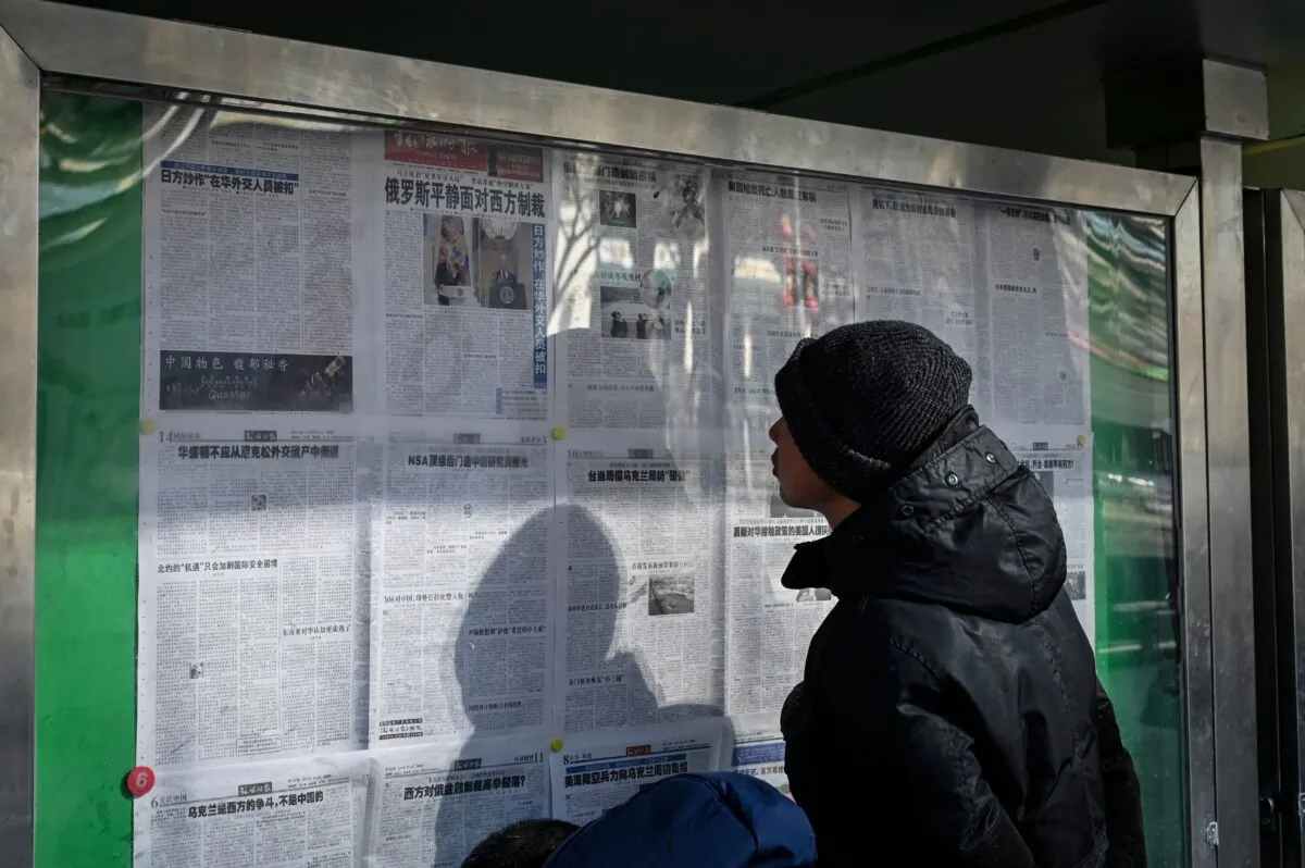 A man reads a Chinese state-run newspaper reporting on the conflict in Ukraine as Russia invades the country, on a street in Beijing on Feb. 24, 2022. (Jade Gao/AFP via Getty Images)