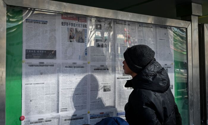 A man reads a Chinese state-run newspaper reporting on the conflict in Ukraine as Russia invades the country, on a street in Beijing on Feb. 24, 2022. (Jade Gao/AFP via Getty Images)
